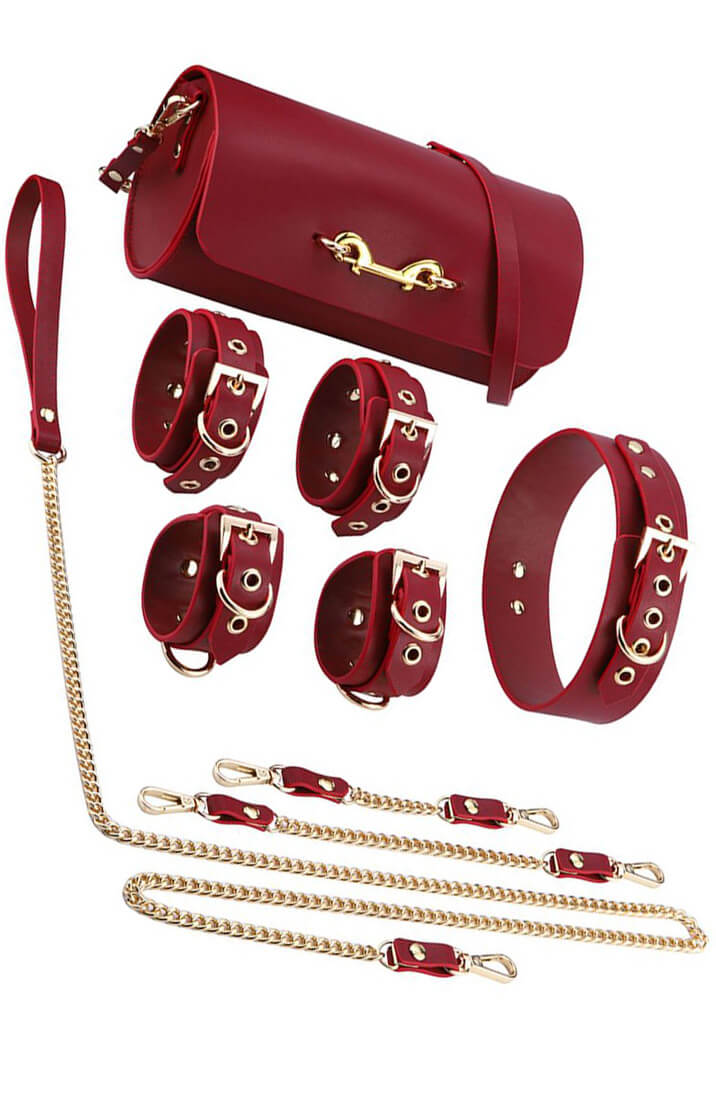 Red BDSM kit with collar, chain, wrist cuffs and ankle cuffs in vegan PU leather
