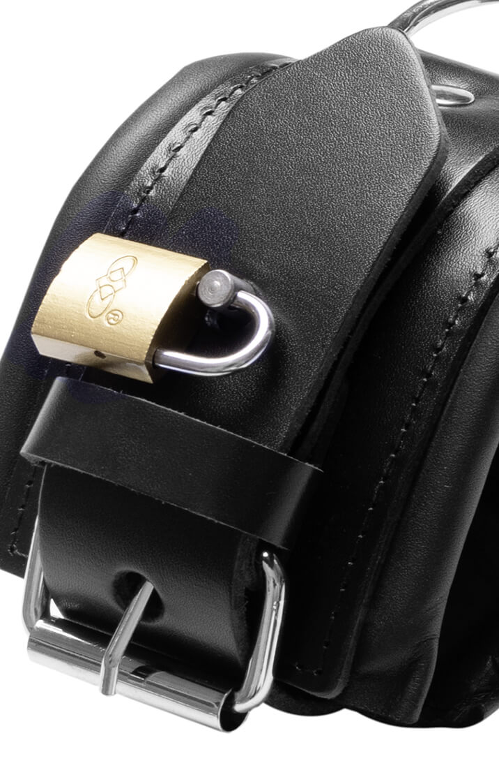 Close-up of black leather ankle cuffs with gold-tone padlocks